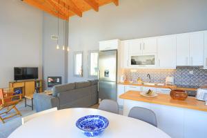 a kitchen and a living room with a table at Villa Christina in Pouládes