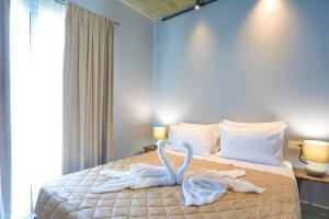 a bedroom with a bed with two swans made out of towels at Villa Christina in Pouládes