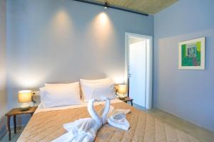 a bedroom with a bed with swans made out of towels at Villa Christina in Pouládes