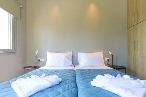 a bedroom with two beds with towels on them at Villa Christina in Pouládes