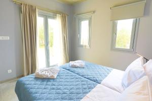 a bedroom with a bed with two towels on it at Villa Christina in Pouládes