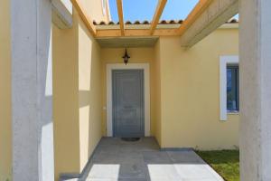 a house with a blue door and a balcony at Villa Christina in Pouládes