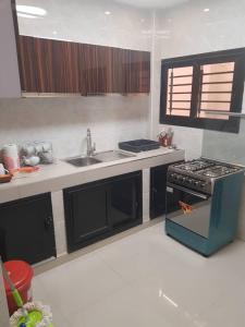 a kitchen with a stove and a sink at Mouna in Dakar