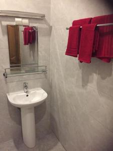 a bathroom with a white sink and red towels at Mouna in Dakar