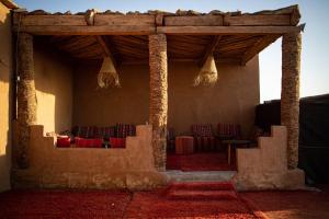 a room with chairs and tables in a building at Desert Luxury Camp in Mhamid