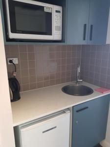 a kitchen with a sink and a microwave at Chatswood Hotel in Sydney