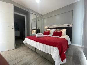 um quarto com uma cama grande e almofadas vermelhas em Acqua Apartments Bariloche em San Carlos de Bariloche