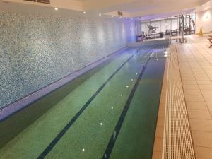 a large swimming pool with green and blue at Chatswood Hotel in Sydney