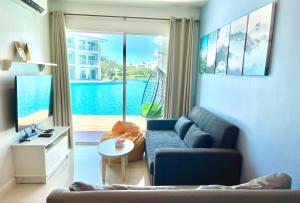 uma sala de estar com um sofá e vista para uma piscina em On-the-Beach Seaview With Direct Pool Access - 1 Bedroom by Sweethome em Ban Bo Khaem