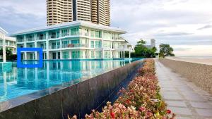 um edifício ao lado de uma piscina ao lado de uma praia em On-the-Beach Seaview With Direct Pool Access - 1 Bedroom by Sweethome em Ban Bo Khaem