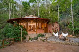 a gazebo with two white chairs in a yard at Chalets HUITACA in Choachí
