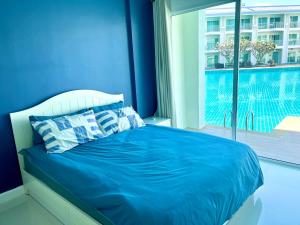 a blue bedroom with a bed and a large window at On-the-Beach Seaview With Direct Pool Access - 1 Bedroom by Sweethome in Ban Bo Khaem