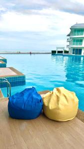 dois sacos azuis sentados ao lado de uma piscina em On-the-Beach Seaview With Direct Pool Access - 1 Bedroom by Sweethome em Ban Bo Khaem