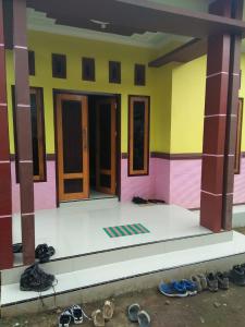 Habitación con puertas y zapatos frente a un edificio en Ijen kingdom guest house en Tamansuruh