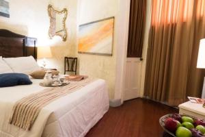 a bedroom with a bed with a bowl of fruit on it at Casa Falleri Boutique Hotel in Lima