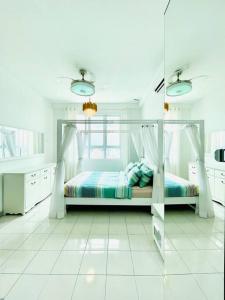 Un dormitorio con una cama en una habitación blanca. en KT CITY HOMESTAY WITH 4 Bedrooms and POOL, en Kuala Terengganu