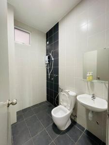 un baño con inodoro y lavabo en KT CITY HOMESTAY WITH 4 Bedrooms and POOL, en Kuala Terengganu