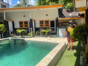 Dos personas frente a una casa con piscina en Club Resort MATAHARI en Gili Trawangan