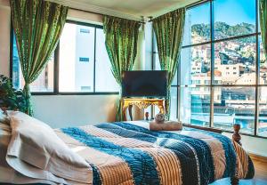 1 dormitorio con cama y ventana grande en The Rooftop Bolivia, en La Paz