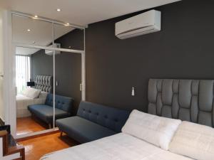 a bedroom with a bed and a blue couch at Cali con amor in Cali