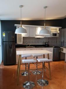 a kitchen with a table and two pendant lights at Cali con amor in Cali