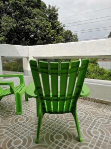 a green chair and a table on a patio at Cali con amor in Cali