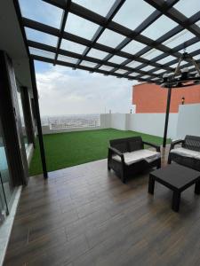 a patio with chairs and a couch on a roof at القمة العالية in Abha +10 photos