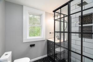 uma casa de banho com um lavatório, um WC e uma janela. em SAND HILL COTTAGE 3 Bedroom Home near PURDUE! River & Park View em West Lafayette