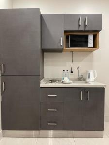 a kitchen with a sink and a microwave at روشن الماسي للشقق المخدومة in Yanbu +25 photos