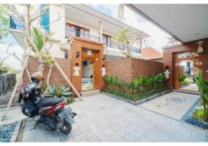 a motorcycle parked in front of a house at Komala Homestay in Canggu +52 photos