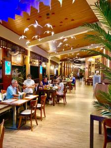 a group of people sitting at tables in a restaurant at Baan Sailom Hotel Phuket - Sha Extra Plus in Karon Beach