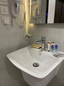 een witte wastafel in een badkamer met een spiegel bij روشن الماسي للشقق المخدومة in Yanbu