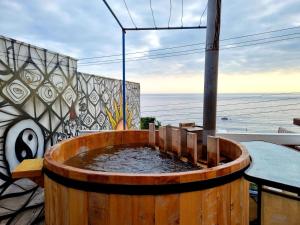 een houten vat gevuld met water naast een tafel bij Quinto Sol B&B in Viña del Mar