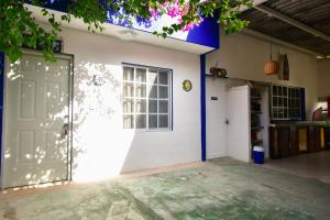 a white garage with a door and a window at Las Palapas de Punta Allen in Tulum