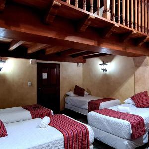 three beds in a room with a staircase at Hotel Casa Real Antigua in Antigua Guatemala