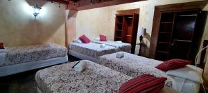a room with three beds in a room at Hotel Casa Real Antigua in Antigua Guatemala