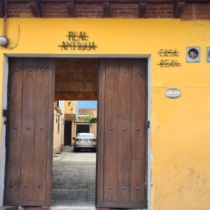 une porte menant à un bâtiment avec un panneau au-dessus de celui-ci dans l'établissement Hotel Casa Real Antigua, à Antigua Guatemala