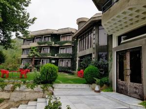 an exterior view of a building with red tables and chairs at Rock City Resort in Mingāora