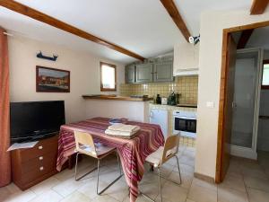 cocina con mesa con sillas y TV en Studio Ideal for guaranteed special moments - by feelluxuryholidays, en Cabrières-dʼAvignon