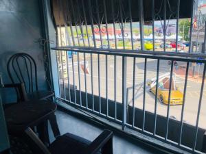 un coche amarillo es visto a través de una ventana cerrada en Greenleaf Guesthouse, en Jerantut