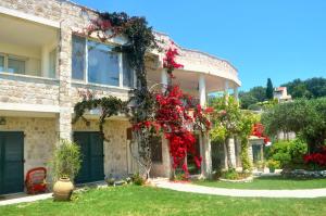 a house with red flowers on the side of it at Haus Lemoni - Studio in Pelekas