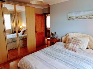 a bedroom with a bed and a mirror at Carnlough Cottage in Carnlough