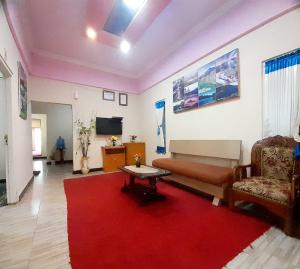 a living room with a couch and a red rug at Shinta Syariah Homestay Dieng RedPartner in Dieng +36 photos