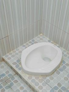 a bathroom with a white toilet in a stall at Shinta Syariah Homestay Dieng RedPartner in Dieng