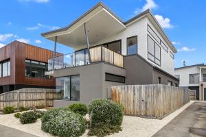 a house with a wooden fence in front of it at Tadasana in Apollo Bay