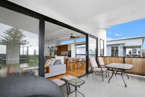 an open living room and dining room with large windows at Tadasana in Apollo Bay