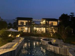 una casa con piscina di fronte a un edificio di MOMIZI INN a Ba Vì