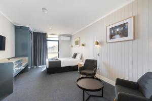 a hotel room with a bed and a chair at The Wine Vine Hotel in Tanunda