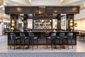 a bar in a hotel lobby with stools at Ramada by Wyndham Diplomat Canberra in Canberra