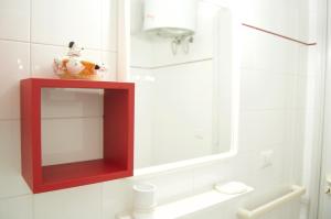 une salle de bain avec un miroir rouge sur le mur dans l'établissement Appartamento BelMar, à Marina San Gregorio 25 autres photos